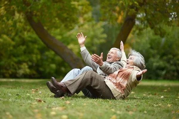 Счастливые старики сидят в осеннем парке