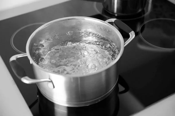 Кипящая вода в кастрюле на электрической плите на кухне